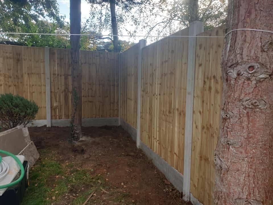 New close-board timber fence on concrete posts and gravel boards around a garden corner