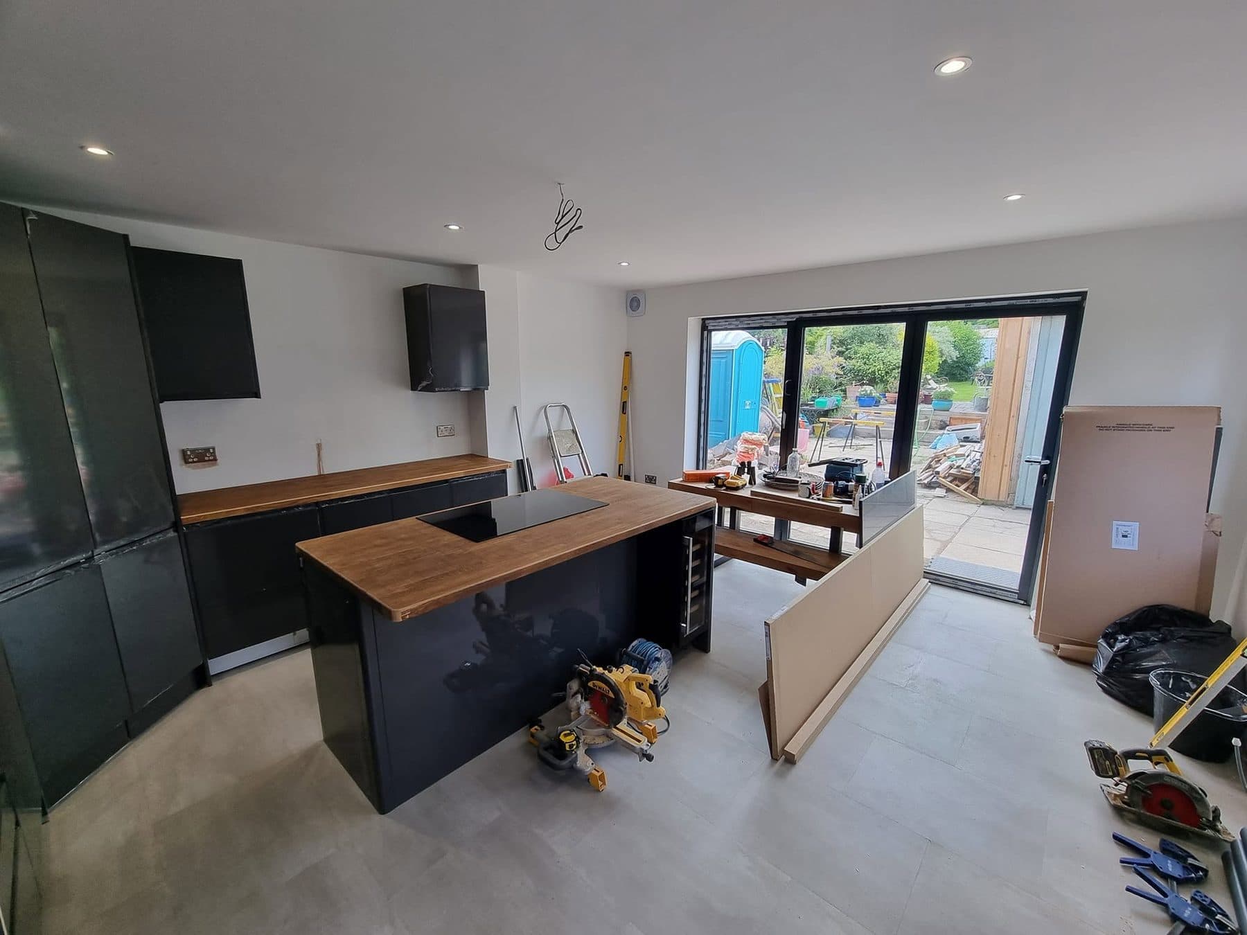 Open-plan kitchen in a new extension, with island and bi-fold doors to the garden