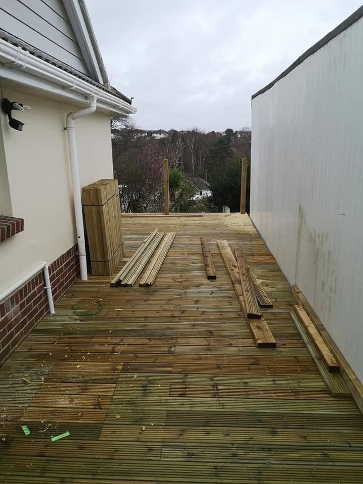 Raised deck walkway with boards laid and balustrade posts up, spindles stacked ready to fit