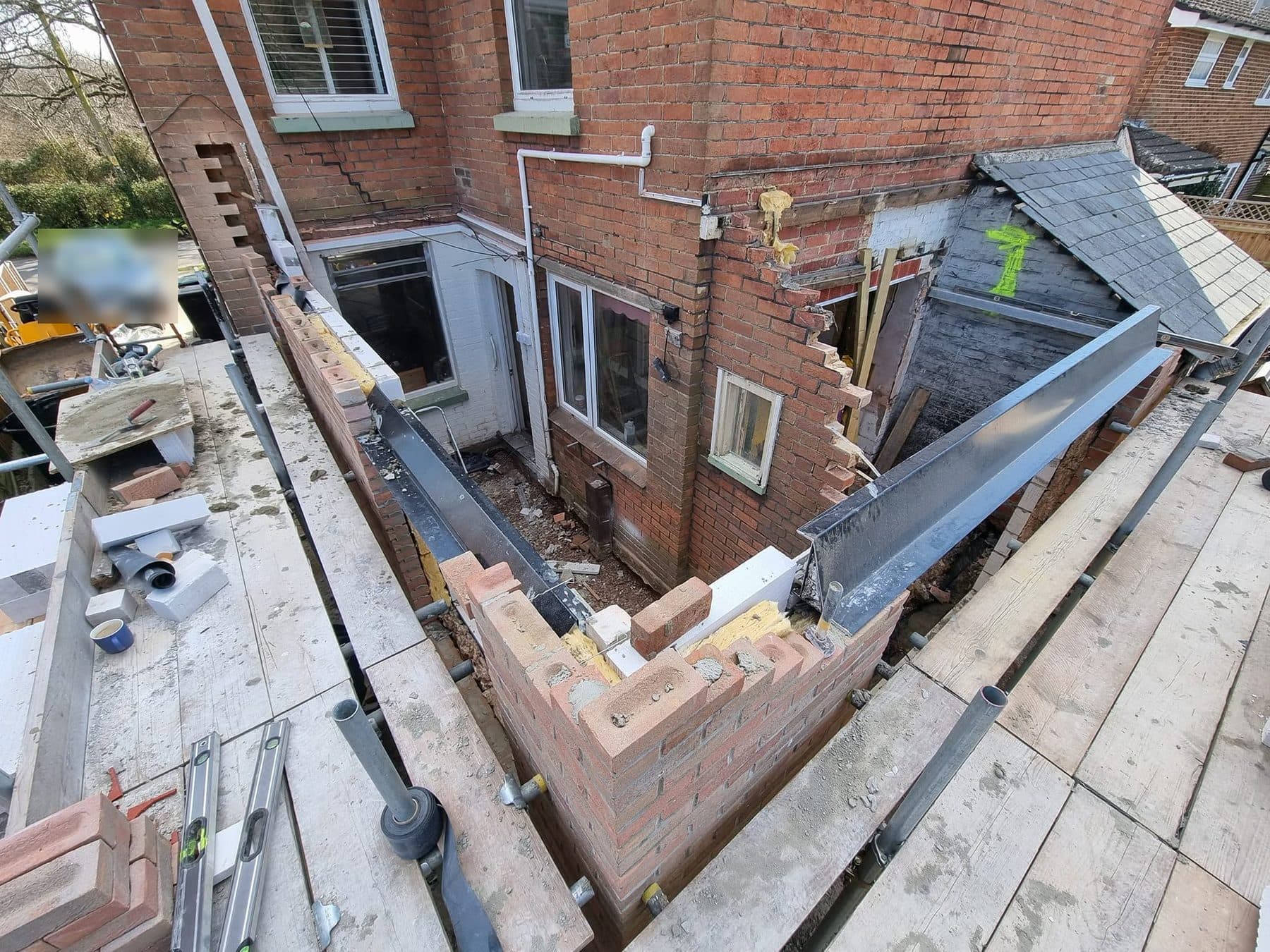 Extension cavity walls built to plate height with steel beams in place, seen from the scaffold