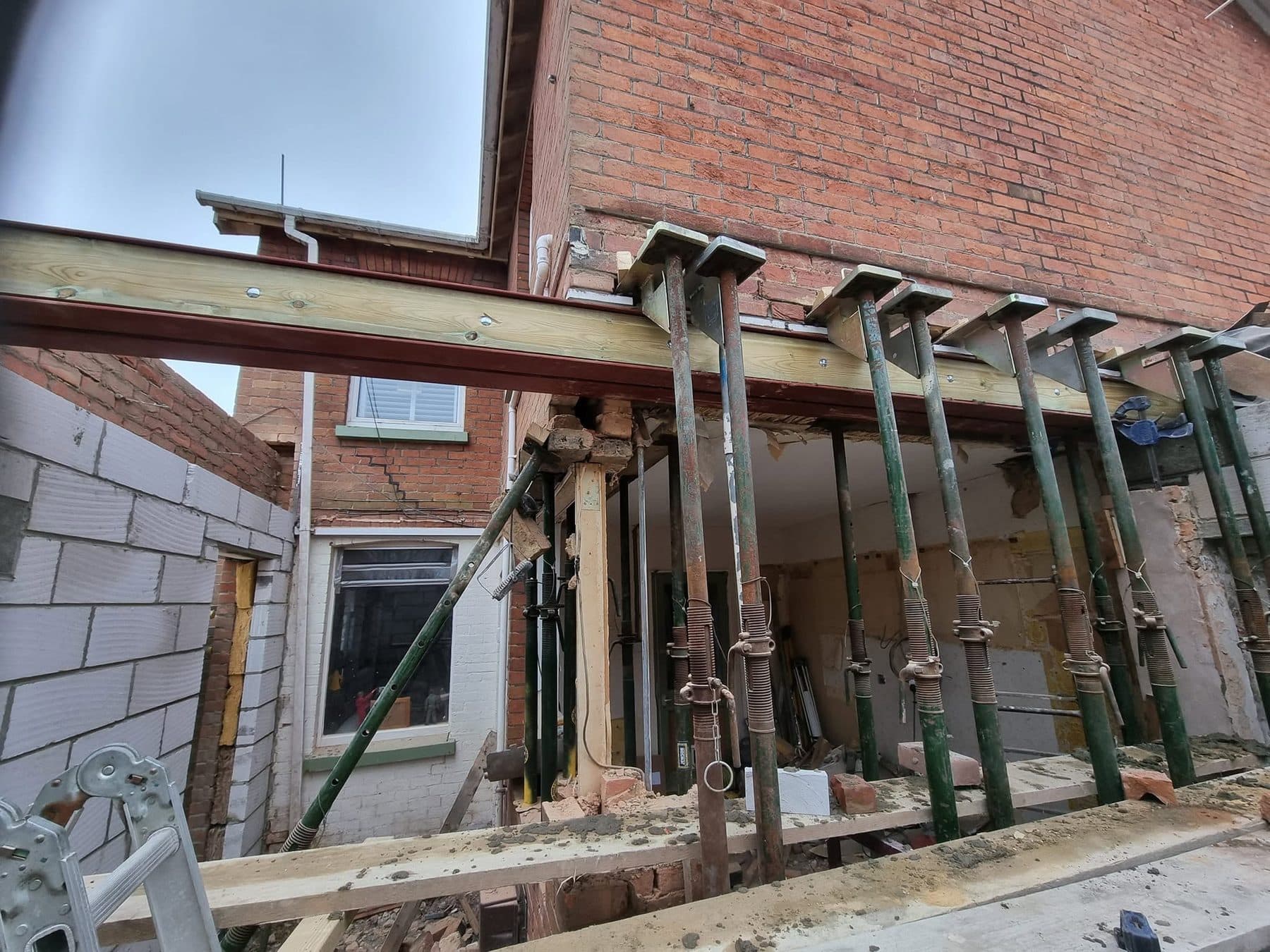 Existing rear wall held up on a row of props and a steel beam while the wall below is removed