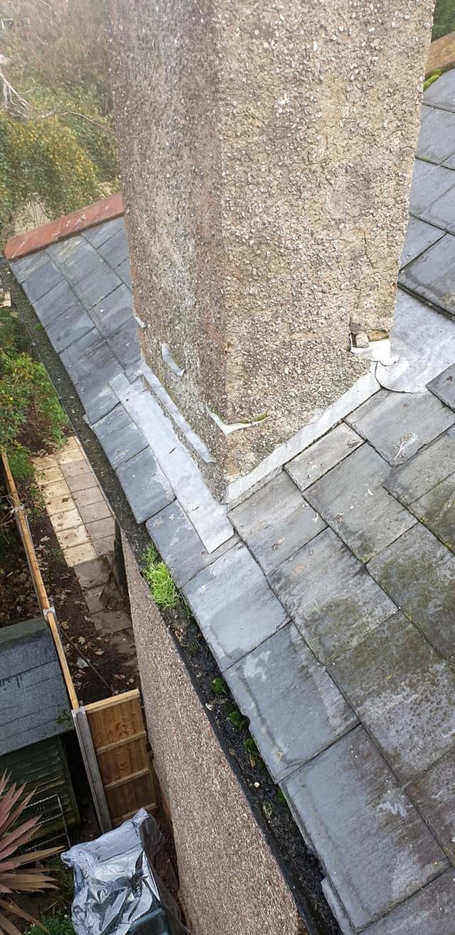 Chimney stack on a slate roof with new flashing dressed round its base, seen from above