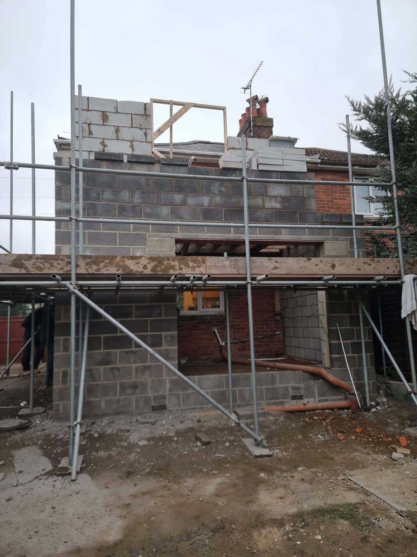 Two-storey rear extension in blockwork with a window former at first floor and scaffold up